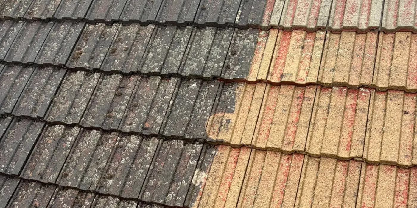 Concrete tiles part way through a clean, black on the left and clean on the right