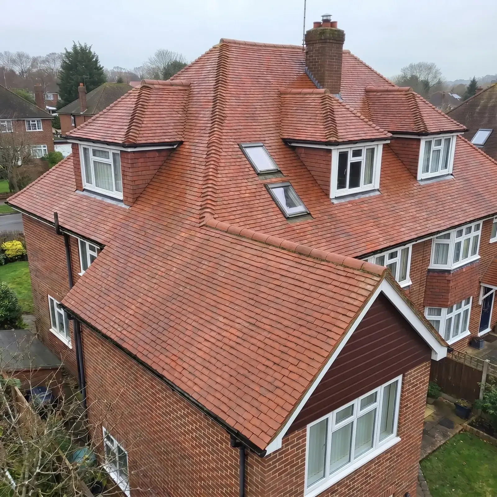 The same dormer roof after cleaning, tiles back to red